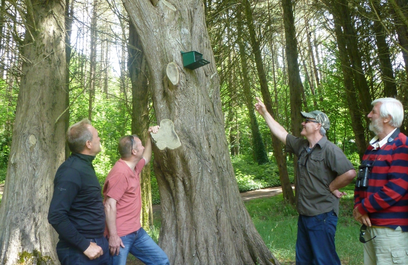 Wildlife expert Dr Nick Fox ( far right) is pictured inspecting one of the 22 feeding stations put up on the island for the red squirrels.