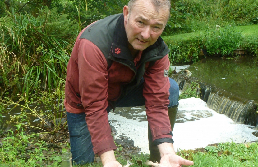 Simon Hart MP is pictured with dead fish that have washed up after a pollution incident near his home near Narberth.