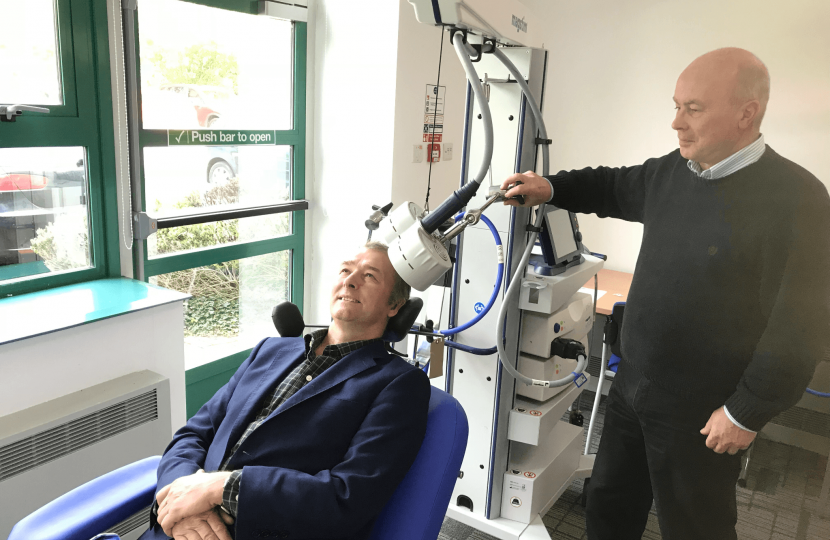 Simon Hart MP is given a demonstration of a TMS therapy chair 